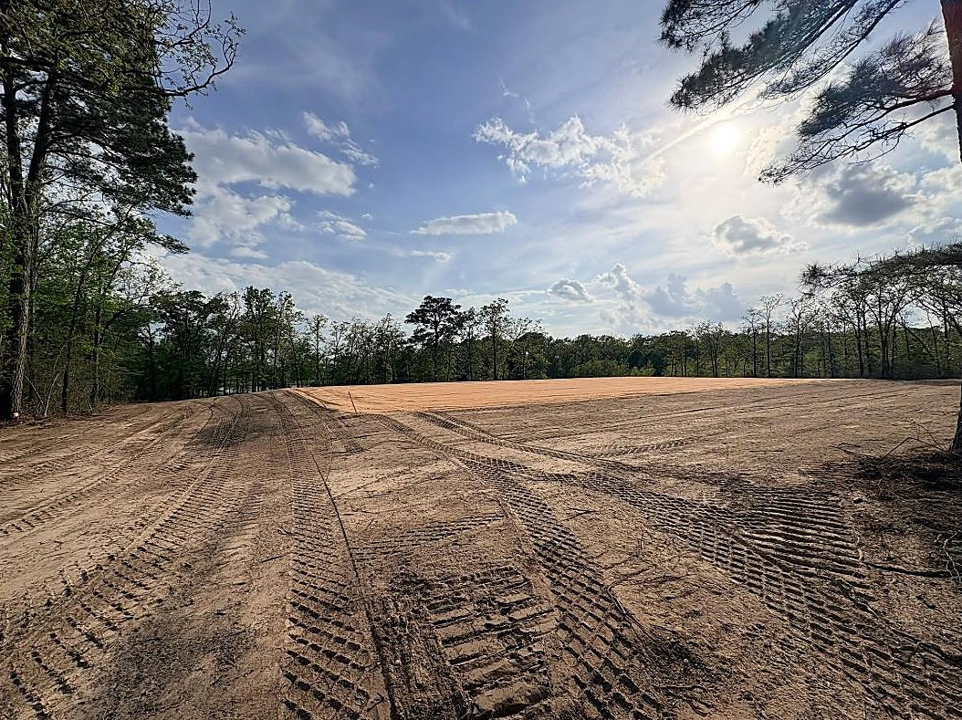 Finished house pad ringed by East Texas pines